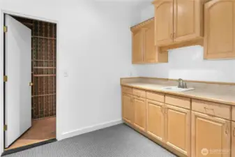 Kitchenette leads to custom wine cellar.