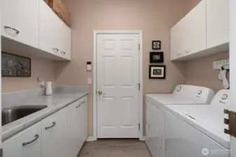 SPACIOUS AND FUNCTIONAL LAUNDRY ROOM - DOOR LEADS TO ENCLOSED UTILITY ROOM THEN 2 CAR GARAGE
