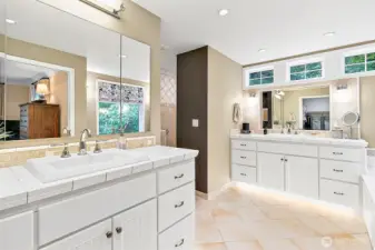 Dual vanities with large mirrors, polished chrome fixtures, and sleek hardware offer both style and functionality, while the radiant heated flooring adds a touch of everyday luxury and comfort.