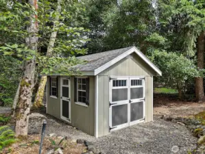 A charming storage shed, newly added in 2022, provides plenty of room for tools, lawn equipment, or hobbies, all while blending seamlessly into the natural landscape.