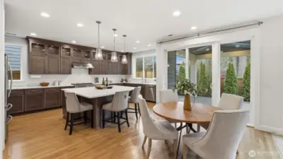 Casual eat-in kitchen with large island leads directly to outdoor covered area.