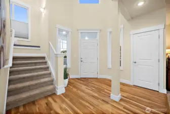 Grand foyer brings in so much light as you enter the house, coat closet just to the right of front door, and formal living room next to closet; carpeted staircase leads you upstairs with handrail.