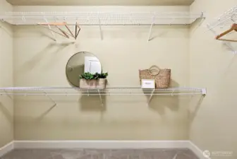 Primary bedroom walk-in closet access through en-suite bathroom with carpeted flooring.