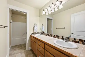 Second full bathroom located upstairs. Double sink vanity and large mirror. Shower/tub and toilet are separated from vanity area with pocket door.