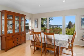 Dining room with recessed lighting, large windows for the view and hardwood flooring.