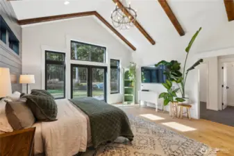 Absolutely stunning and spacious owner's retreat. Soaring wood beamed ceilings, chandelier, light filled windows bring the outside in. Custom painted shiplap wall anchors the space.