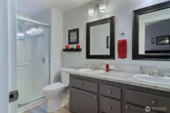 Remodeled primary bathroom with the same lovely quartz counters and large shower