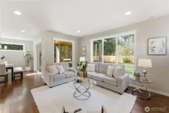 The living room showcasing the gorgeous large windows and hardwood floors