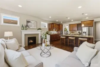 A view from the living room into the adjacent kitchen, featuring rich cherry cabinetry, a large island, and abundant storage