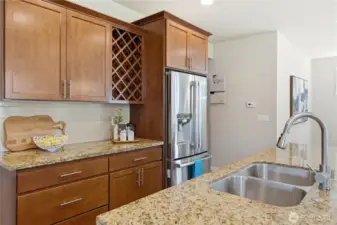 Warm cherry cabinetry and a highly functional double sink, complemented by a stainless steel refrigerator with convenient water and ice dispensing