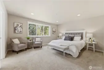 At the far end of the hallway, the privately located primary bedroom offers a spacious retreat with calming colors, an ensuite bathroom, and abundant natural light.  Staged with a King size bed