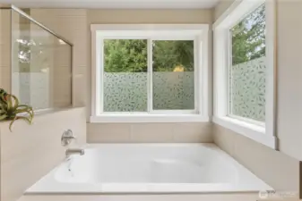 Close-up of the bathtub drenched in daylight, with only the garden beyond—privately positioned in the corner of the property with no neighboring homes