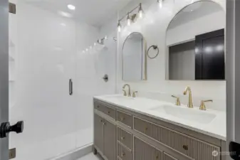 Primary bathroom - STUNNING custom shower with double vanity & custom gold features. Incredible attention to detail in this ensuite, including built-in shelving in the primary shower.