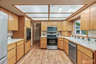 Solid oak kitchen cabinets, vinyl flooring, stainless appliance package (new in 2022) and tile countertops.  Lighting panel is in process of being replaced, please excuse.