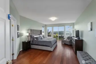 The spacious main-floor primary suite enjoys a slider onto the deck, and low-maintenance hardwood floors.