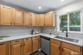 From the kitchen window, enjoy a lovely view of the fully enclosed backyard, where a mature apple tree offers shade and a charming pet enclosure offers flexibility of use.