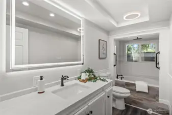 Located in the hall and central to the 3 bedrooms, this conveniently located full bathroom is spacious and beautiful with a large LED vanity mirror, and a new vanity featuring a sleek white quartz counter and abundant storage.