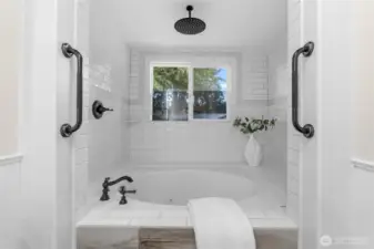 Enjoy a spa-like setting where you can unwind with a hot soaking bath or refresh with a quick shower—either way, you'll appreciate the custom white tile and sleek black hardware.