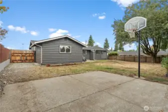 A gated entry to the backyard provides the option to securely store larger items or even a vehicle, all enclosed within the fenced yard.