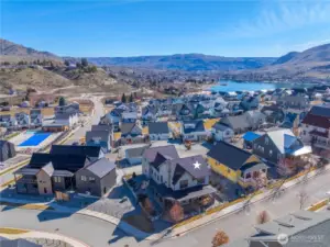 Aerial view of home looking west towards downtown Chelan with the heated year-round Vineyard District pool to the left.