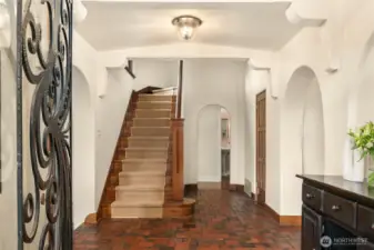 Central front hall, with a tile floor and a nod to perhaps a bit of a Santa Barbara feel in all those arches!
