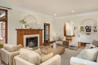 In this photo you can see how the living room sits down front he central hall.  The door you see open next to the fireplace leads to a cozy den or office.