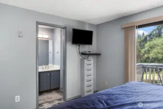 Primary bedroom has sliding glass doors to a quaint deck.