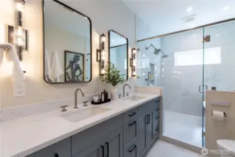 Spa-inspired primary bath featuring a state-of-the-art Toto G5 Washlet, dual vanities with elegant high end Brizo fixtures, and a glass-enclosed shower with dual shower heads, complemented by a serene soaking tub.