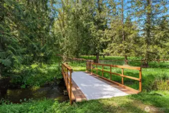 Sanctuary setting with bridge to additional acreage and fenced paddock.