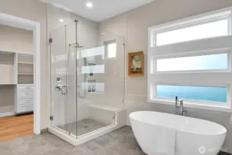 Main level primary ensuite complete with soaking tub, heated tile floors, floor to ceiling tiled shower w/ bench, floor motion sensor lights, custom walk-in closet, double quartz vanities, private toilet room...