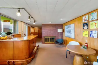 The finished basement continues the MidMod vibe with a groovy lounge, second fireplace, and substantial wood bar that feels made for records, conversation, and unforgettable gatherings.