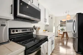 Newer microwave range hood, glass cooktop facing the dining nook
