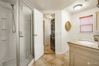 3/4 bath with travertine tiled floors and granite countertop.