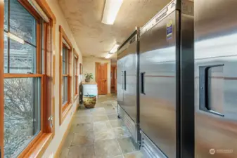 Laundry room~showcasing refrigerator ~freezer and door to the attached living space