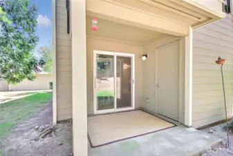 Covered patio with extra storage and yard.