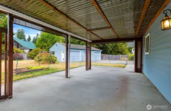 Covered back patio looking towards the detached garage/shop.