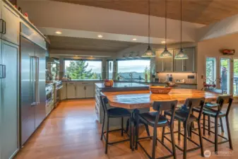 This is a chef's dream kitchen. So many details: custom cabinets with granite suede finish counter tops.  The drawers are all soft close with heavy duty glides. Deeper drawers hold dishes and other heavy equipment. One cabinet has a pop up shelf for a stand mixer so you don’t have to lift it. All cabinets have pull out shelves so it’s easy to reach things in the back. One upper cabinet has slots to store trays, cutting boards and baking sheets. There is a built in spice shelf and a cabinet for trash. A favorite feature is the stove hood with infrared warming lights and warming shelf.