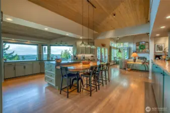 Vaulted ceilings, big windows, detailed lighting, over sized island with seating, a place for a conversation, contemplate the day or planning a celebration. This space will become your favorite hang out.
