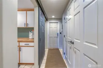 Hallway off kitchen: double door closet, laundry room, stairway to upper level and access to the 2+ car garage.