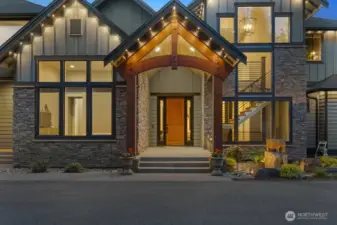 A striking Whistler-inspired entrance framed by stacked stone, rich timber beams, and dramatic architectural lines. The grand covered portico creates a warm and inviting arrival, while expansive windows showcase the home’s refined interior. An integrated smart holiday lighting system highlights the architecture year-round, allowing you to celebrate every season with elegance and ease.