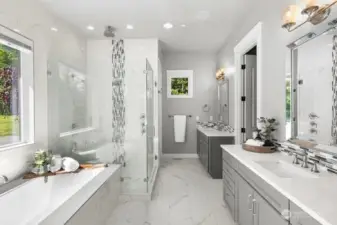 Luxurious primary spa bath with view windows, soaking tub, rain shower and double sinks.
