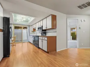 wide galley kitchen that opens to eat in nook and dining area