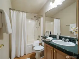 Hall bathroom with tub/shower, single vanity and cabinets for extra storage.