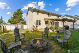 Rearview of the yard showcasing the firepit and greenhouse.