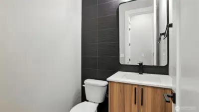 Main Level Powder Room, with its floor-to-ceiling tile work on the accent wall.