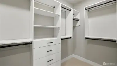 One of two massive walk-in closets of the Primary Suite. Custom wood racks in all the closets (no wire racks in this house!)