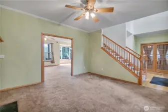 Living room has one of five ceiling fans. French doors to the right open to an office area.