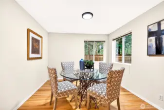 The dedicated dining room provides a bright and versatile space for everyday meals or special occasions, with hardwood floors, corner windows overlooking the private backyard, and a quiet separation from the main living area that makes the room feel intentional and complete.