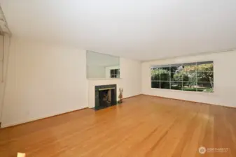 Gleaming oak hardwood floor in living room with gas fireplace and huge window to the rear yard. Looking west south west.