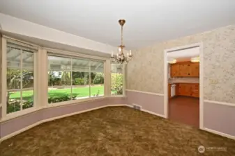 Large Dining Room with another wall of windows to enjoy the backyard greenery view. Those carpets are covering the oak hardwood flooring.  Kitchen is through the door.